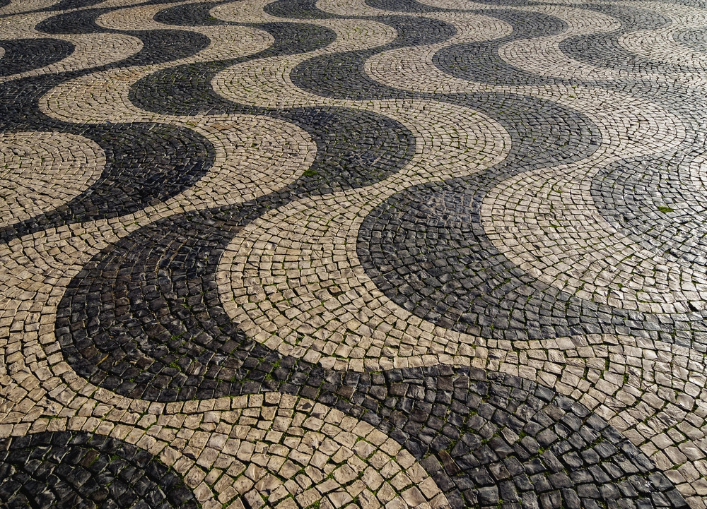 Układanie kostki brukowej w falisty wzór z czarnej i białej kostki