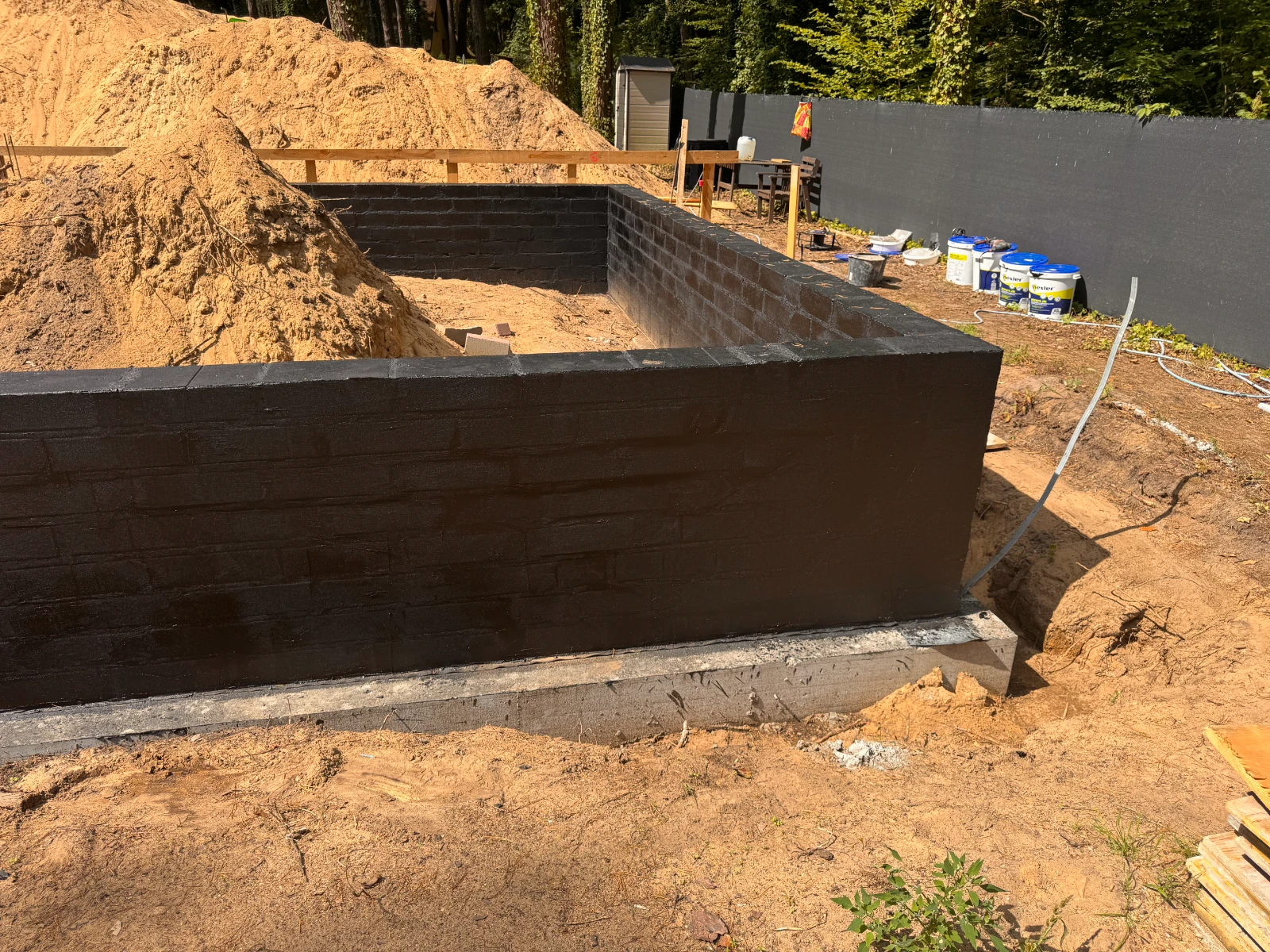 Izolacja fundamentów – zabezpieczenie czarną masą bitumiczną ściany z bloczków